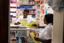 Source - PSI. Pharmacy workers discussing the various commodities available. 